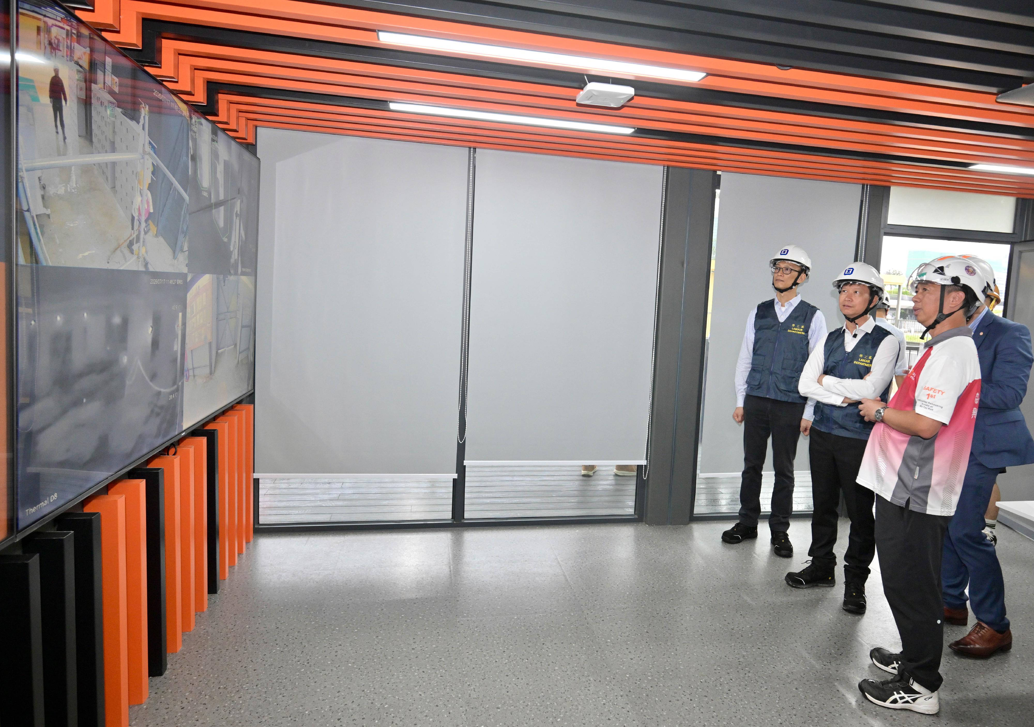 The Commissioner for Labour, Mr Sam Hui, and the Deputy Commissioner for Labour (Occupational Safety and Health), Mr Ivanhoe Chang, visited a construction site in To Kwa Wan today (July 17) to learn about anti-smoking measures implemented by a contractor. Photo shows a representative of the contractor briefing Mr Hui (second left) and Mr Chang (first left) on relevant fire prevention measures of the Smart Site Safety System at the site.