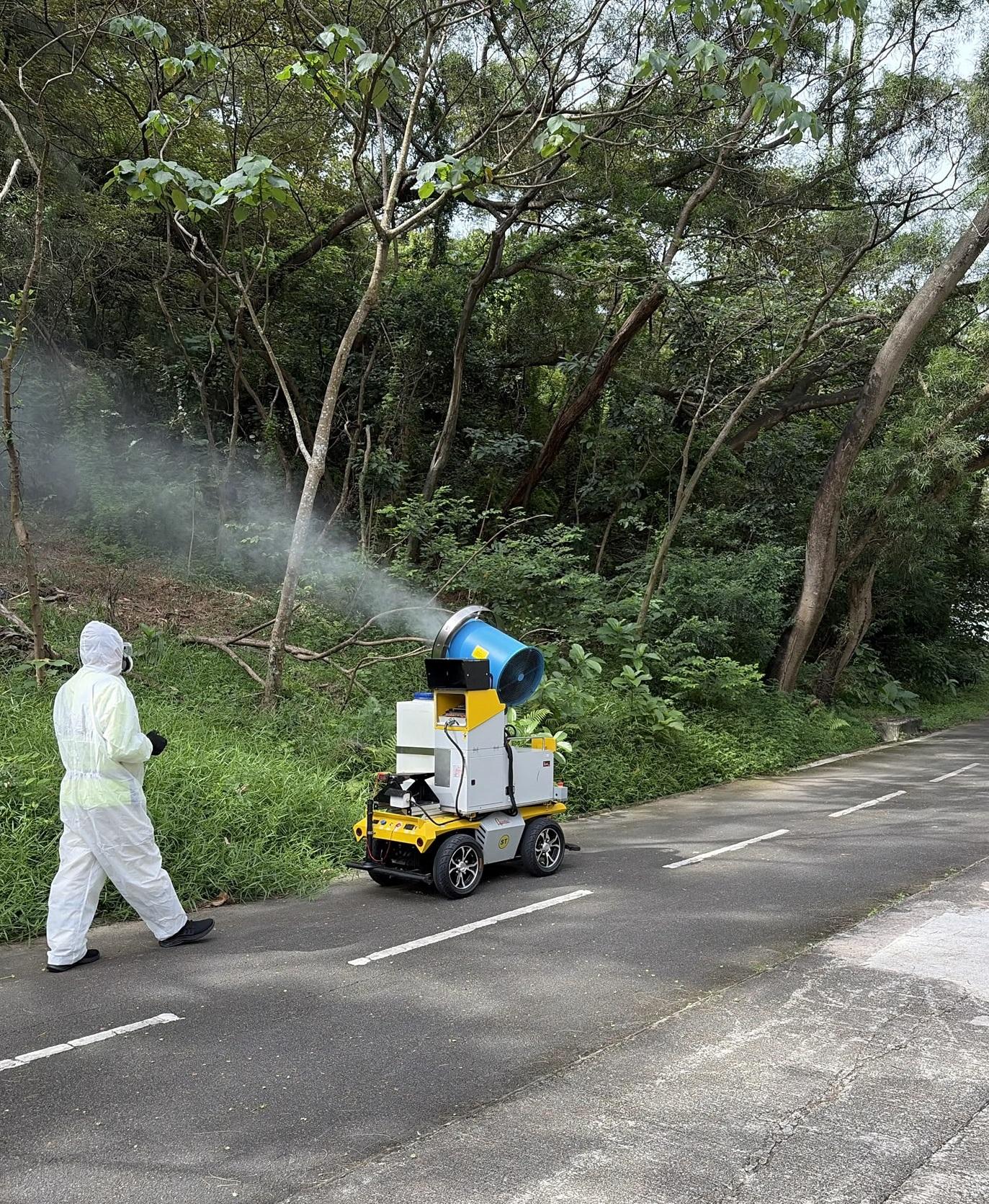 The Food and Environmental Hygiene Department (FEHD) today (July 17) released the third batch of gravidtrap indexes and density indexes for Aedes albopictus in July, covering 23 survey areas. Photo shows a staff member of the FEHD's contractor conducting a fogging operation with a mechanical ultra-low volume fogger in the vicinity of Ma On Shan, Sha Tin District, to eliminate adult mosquitoes.